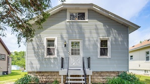 A two-story house with a front porch, a set of stairs leading to the entrance, and a small garden area. - Westmont Home w/ Hot Tub! Walk to Metra Station (Westmont)