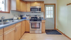 A modern kitchen with wooden cabinets, stainless steel appliances, and a built-in microwave. - Westmont Home w/ Hot Tub! Walk to Metra Station (Westmont)