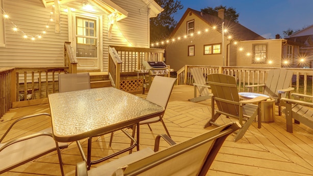 A wooden deck with a glass-top table and chairs, a grill, and string lights. - Westmont Home w/ Hot Tub! Walk to Metra Station (Westmont)