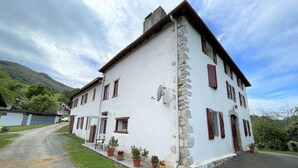 A two-story building with a stone facade, multiple windows, and a paved driveway. - BELAZKABIETA - ESPELETTE (ESPELETTE)