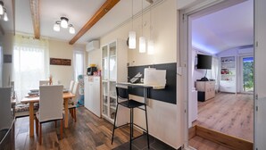 Una cocina moderna con comedor, televisor y puerta corredera que da a un balcón.