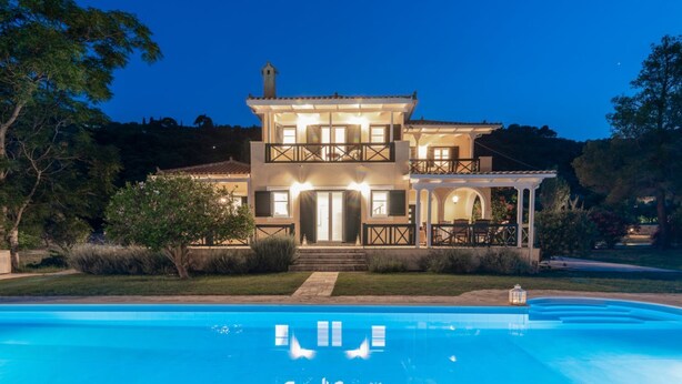 Una casa de dos pisos con una piscina delantera.