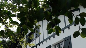 A white building with a black staircase and red planters. - GURE GOSTUAN - ITXASSOU (ITXASSOU)