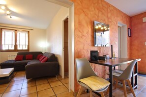 Relax in this stylish living room with a sofa, dining table, and flat-screen TV.