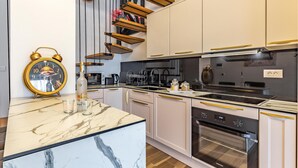 A modern kitchen with a marble countertop, stainless steel appliances, and a built-in oven. - 4 bedroom lovely apartment in Medulin (Medulin)
