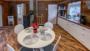 A cozy kitchen with a dining area, wooden floors, white cabinets, and a central table with chairs. - Nice home in Kåphult with kitchen (Kåphult)