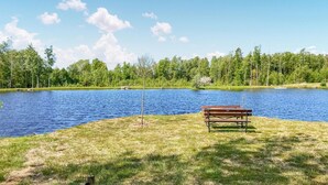 A lakeside view with a picnic table and a bench by the water. - Nice home in Kåphult with kitchen (Kåphult)