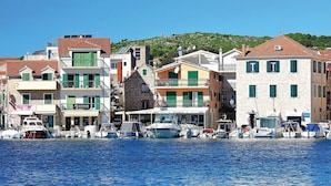A coastal town with buildings along the waterfront, boats docked, and a clear blue sky. - Lovely apartment in Vodice (Vodice)
