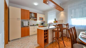 Una cocina moderna con armarios de madera, una isla central y taburetes de bar.
