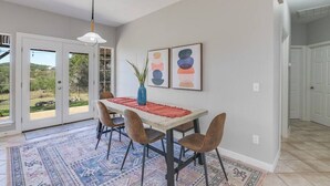 Un comedor con una mesa, sillas y un tapete.