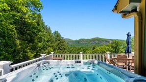 A hot tub with a view of mountains, surrounded by a white deck and outdoor furniture. - Luxury Home with MountainViews•PoolTable•Chefs Kitchen•FirePit (Lake Lure)