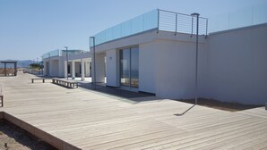 Un edificio moderno con ampie vetrate e un terrazzo in legno.
