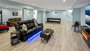 A modern living room with a leather sofa, a coffee table, and a flat-screen TV. - Quiet neighborhood near it ALL, Sleeps 12, Pet Friendly, Swamp Cooler (Centennial)