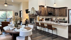 Une cuisine moderne avec des meubles de couleur sombre en bois, un plan de travail en granit et un four à micro-ondes encastré.
