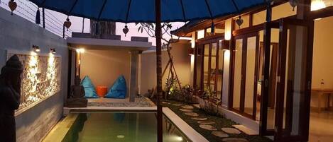 Una piscina al aire libre, tumbonas