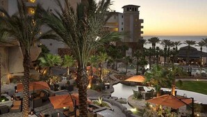 Un complexe hôtelier doté d’espaces de détente en plein air, de palmiers et offrant une vue sur l’océan.