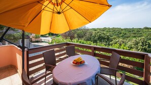 A balcony with a table, chairs, and a yellow umbrella. - Awesome apartment in Kavran with WiFi (Kavran)