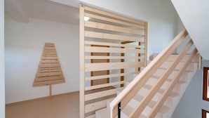 Een trap met houten leuningen en een houten spijlenwand.