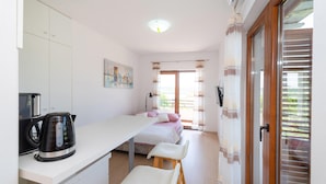 Een compacte kamer met kitchenette, een bed en uitzicht op de omgeving.