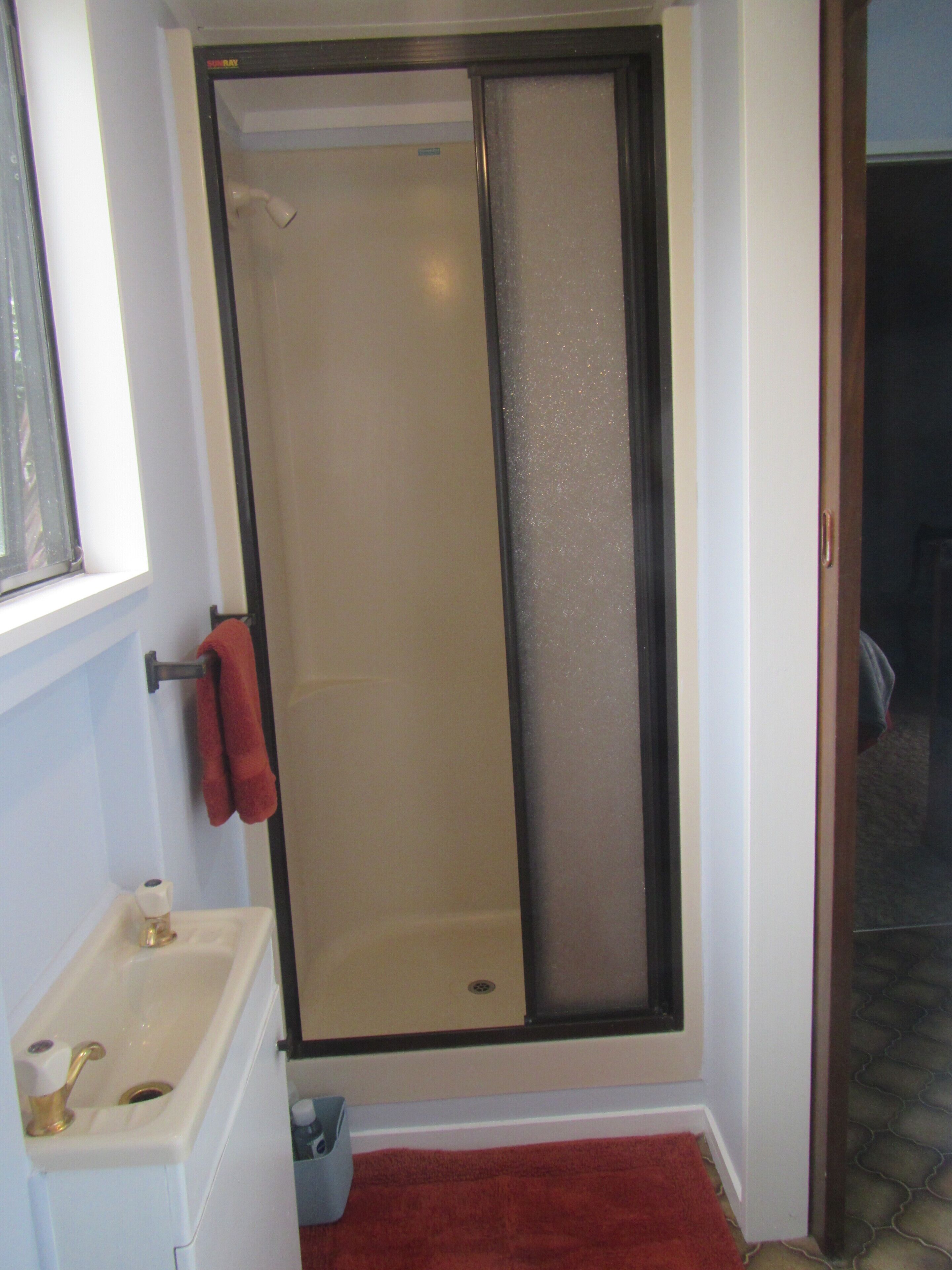 A bathroom with a shower, a toilet, and a sink.