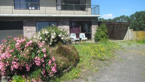 Et toetagers hus med balkon, garage og have med pink og gule blomster.