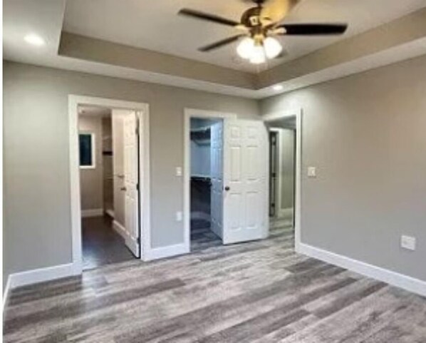 Comfortable room with a high ceiling, hardwood floor, and a closet.