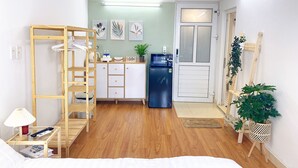 A compact room with a kitchenette, a wooden ladder, a bed, and a small table with a lamp. - Hanoi Old Quarter Center - 1BR Studio - Big window & Balcony & Private Bathroom (Hà Ni)