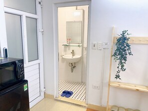 A compact kitchen with a microwave, a sink, and a small countertop.