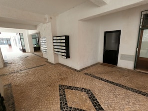 A hallway with tiled flooring, a wall-mounted mailbox, and a door. - Algarve, modern T1 apartment with/balcony, Quarteira (Quarteira)