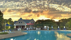 A swimming pool with lounge chairs and a building with a red roof. - Dockside - Picture Perfect Home - Gorgeous Views! (Arapahoe)