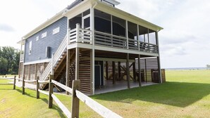 A two-story building with a balcony, a staircase, and a view of the surrounding landscape. - Dockside - Picture Perfect Home - Gorgeous Views! (Arapahoe)