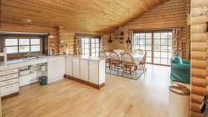 A log cabin interior with a kitchen, dining area, and a cozy seating area. - 3 bedroom stunning home in Samsø (Samsø)