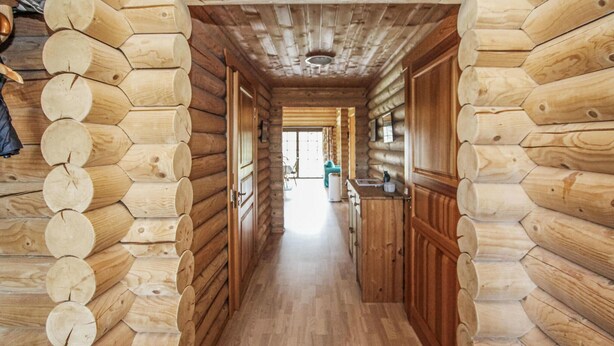 A log cabin interior with a wooden floor and walls made of logs. - 3 bedroom stunning home in Samsø (Samsø)