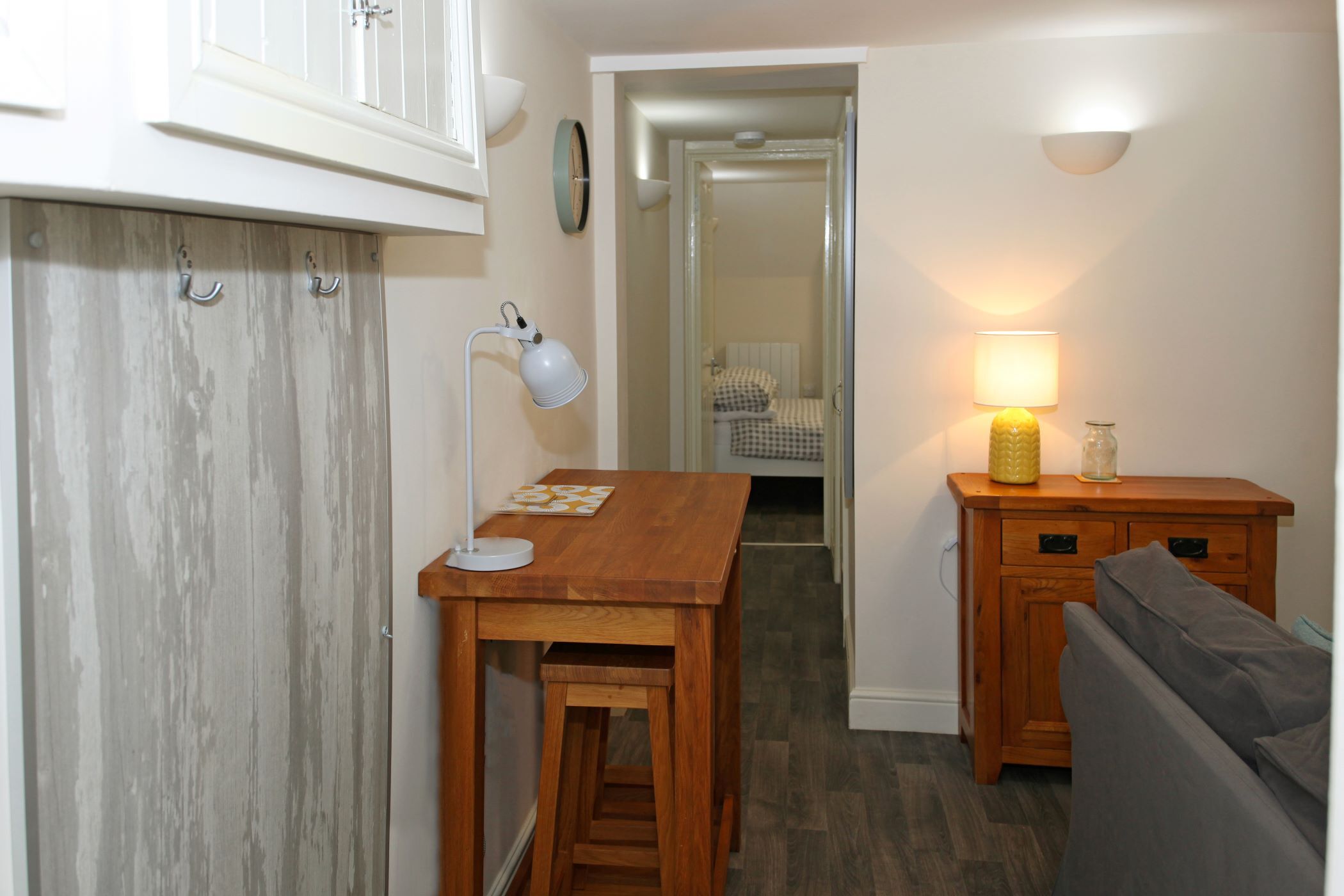 Una cocina compacta con una mesa de madera, un banco, un armario y una lámpara.