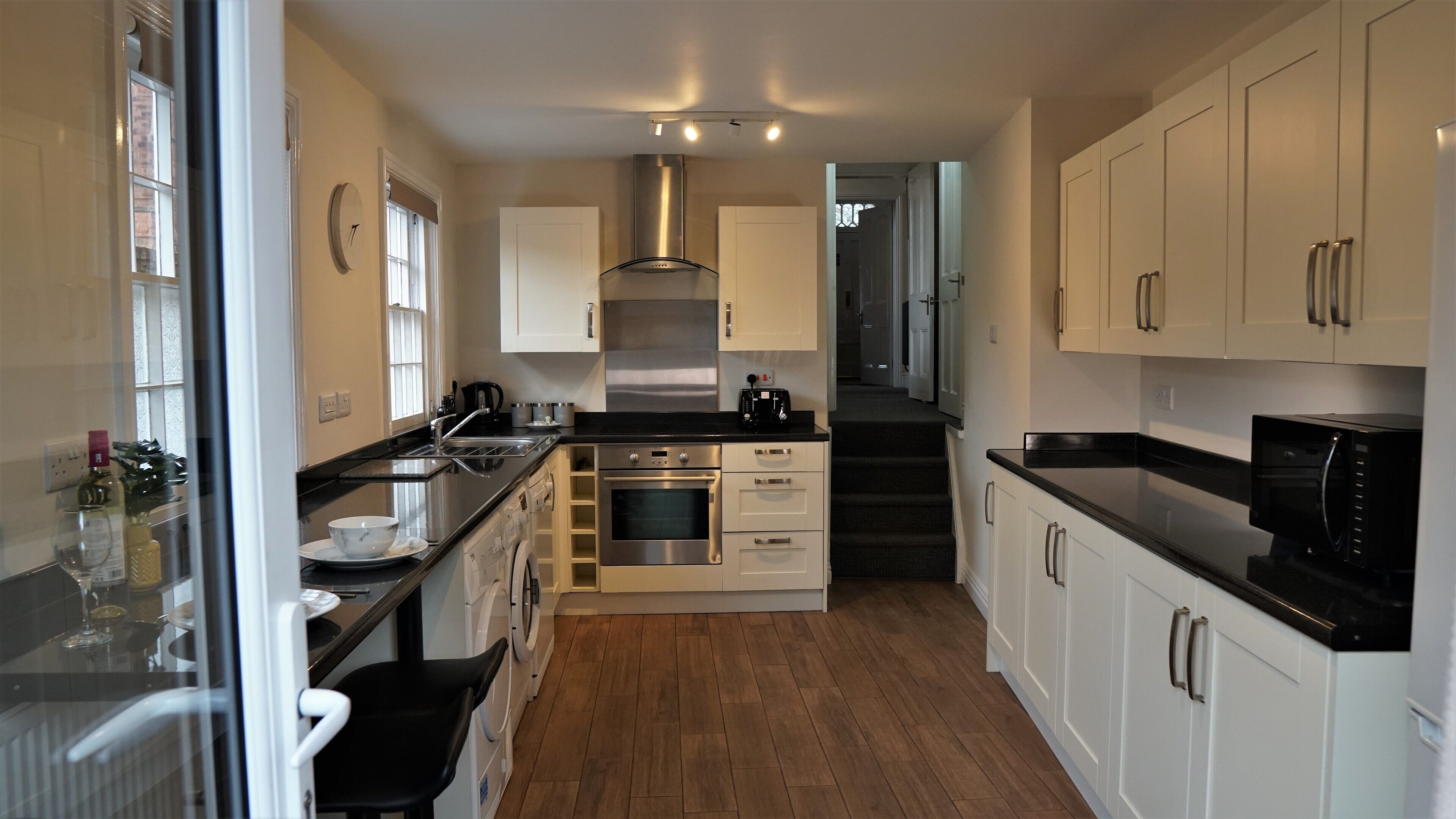 A compact kitchen with a central island, stainless steel appliances, and a microwave.