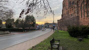 A street with a bench, a building, and a clear sky.