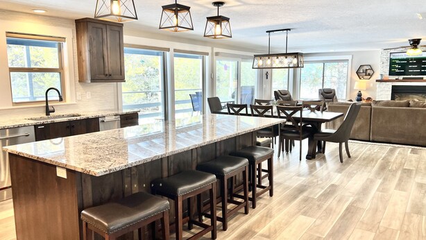 Una cocina moderna con una isla grande, taburetes de bar y un comedor con sillas y una mesa.
