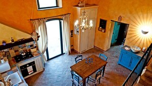 Una cocina con estufa, lavaplatos y comedor con sillas y una mesa.
