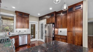 A modern kitchen with dark wooden cabinets, stainless steel appliances, and granite countertops. - Welcome To Your New Favorite Spot! Tree Top Views & Lots Of Room! (Salem)
