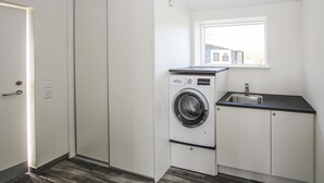 A compact laundry room with a Bosch washing machine, a sink, and a window above the counter. - 3 bedroom gorgeous home in Samsø (Samsø)