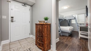 A room with a bunk bed, a small desk, and a wooden cabinet. - Dune Pointe 102 * Fall Rates Reduced * Salt Water Vacations (Fort Walton Beach)