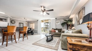 A spacious living area with a ceiling fan, a dining table with chairs, a sofa, and a coffee table. - Dune Pointe 102 * Fall Rates Reduced * Salt Water Vacations (Fort Walton Beach)