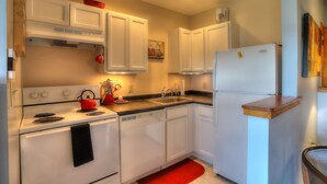 A kitchen with white cabinets, a stove, a sink, and a refrigerator. - 7 Grandview - Unit D - Great condo close to downtown Rangeley (Rangeley)