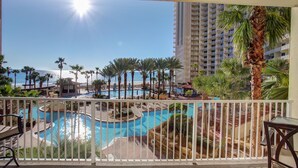 A resort pool area with multiple pools, palm trees, and a view of the ocean. - 2 Bedroom in Shores of Panama - Same floor reserved parking and stunning views! (Panama City)