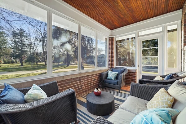 Four season porch with outdoor furniture in view of pine trees and backyard. Relax and enjoy happy hour or a summer's evening breeze in this cozy screened in porch area. No smoking.