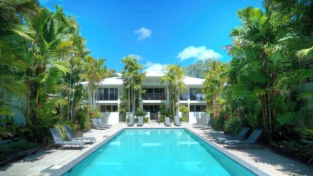 A swimming pool with lounge chairs and palm trees. - Sea La Vie - Port Douglas Villa (Port Douglas)