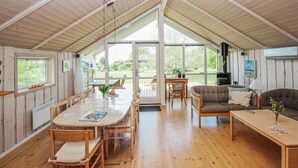 A cozy cabin interior with a dining area, a sofa, and a fireplace. - 3 bedroom lovely home in Samsø (Samsø)