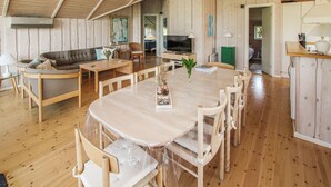 A wooden interior with a dining table, chairs, a sofa, and a television. - 3 bedroom lovely home in Samsø (Samsø)