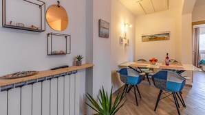 A dining area with a table, chairs, and a potted plant.