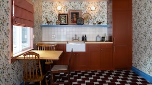 A kitchen with wooden cabinets, a tiled backsplash, and a checkered floor.